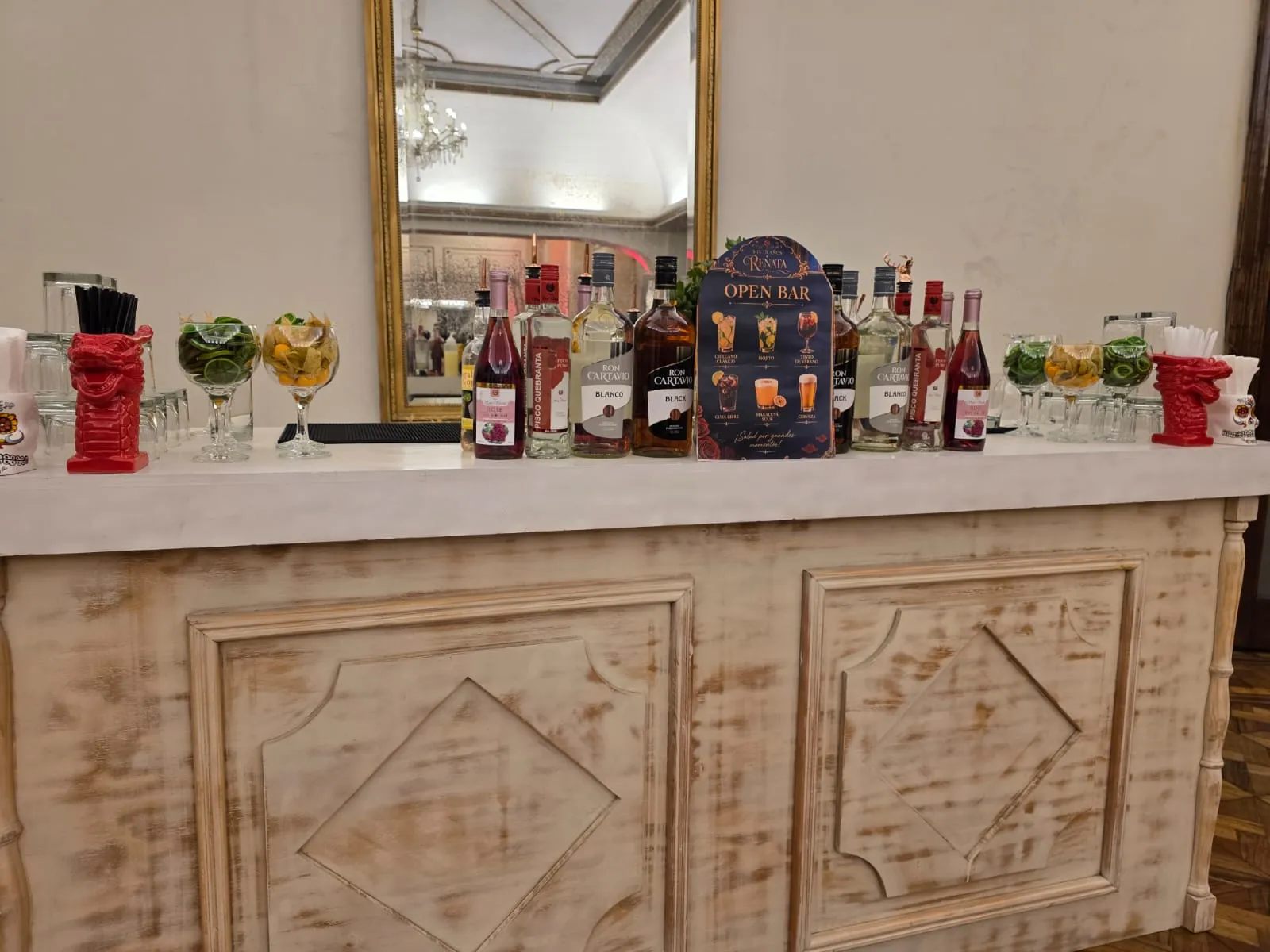 Barra de open bar montada con botellas y cristalería